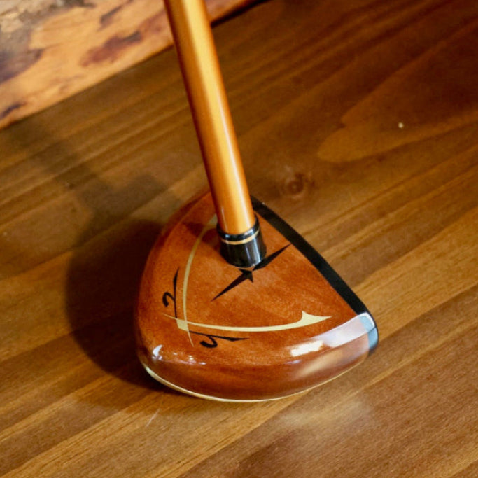 Wooden golf club head on a wooden surface
