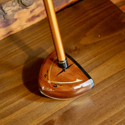 Wooden golf club head on a wooden surface